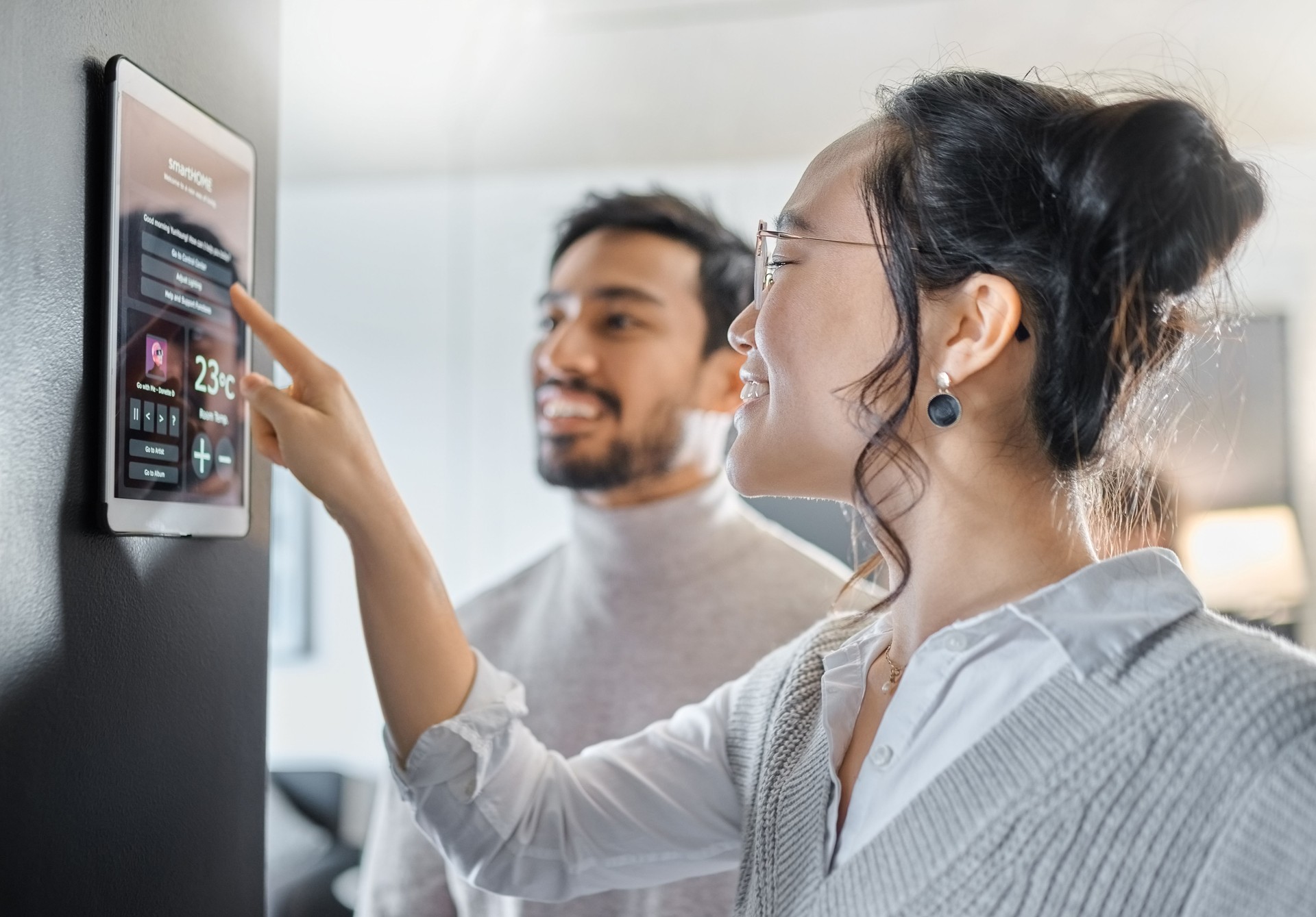Smart home technology, wall system and couple with digital dashboard for air conditioning, safety security network or house automation. App software, ui panel and Asian people programming IOT monitor
